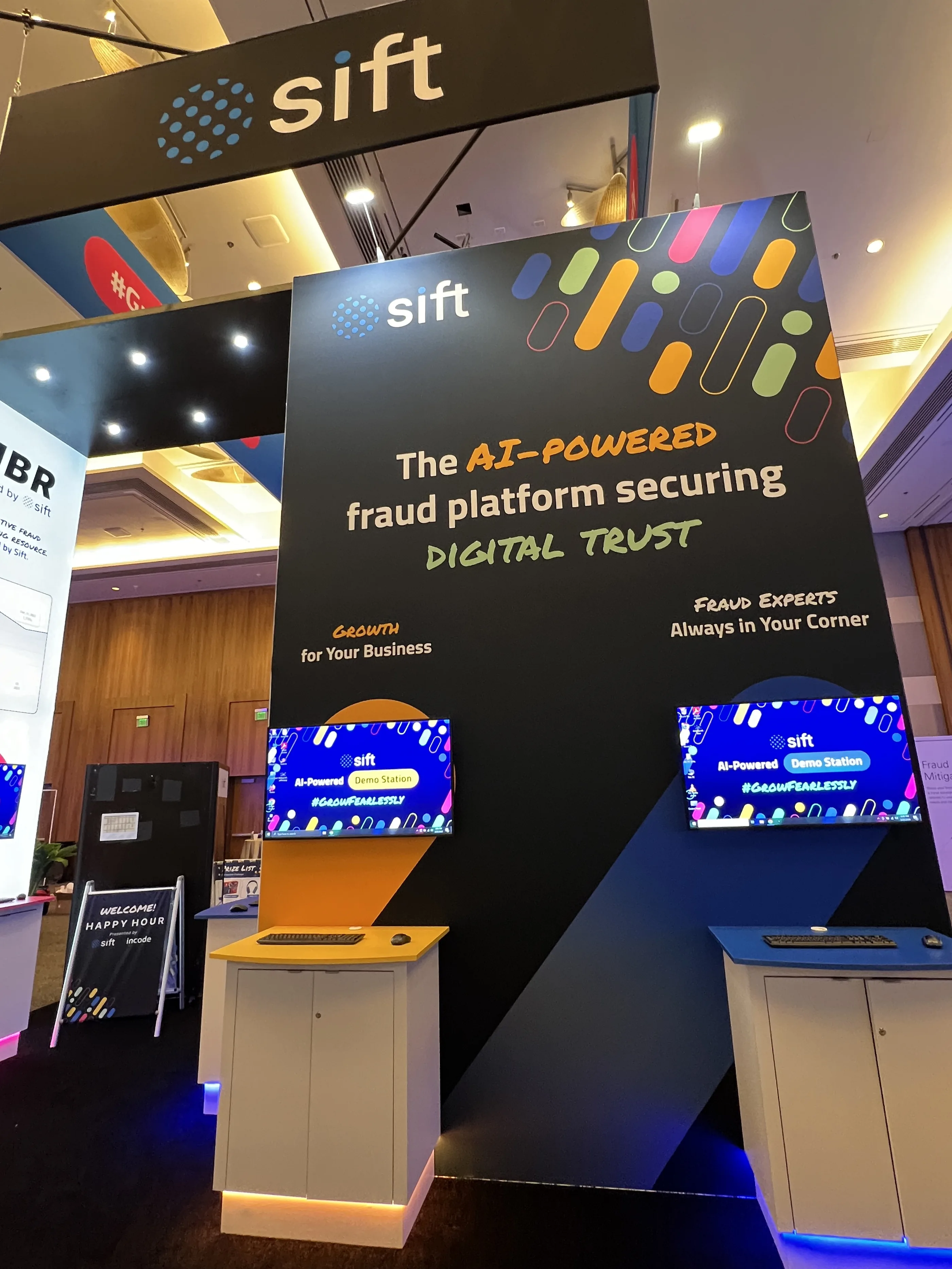 Sift booth showing the large LCD messaging screen and colourful demo stations.